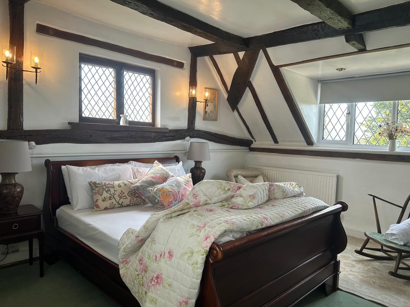 A beamed bedroom with sleigh bed